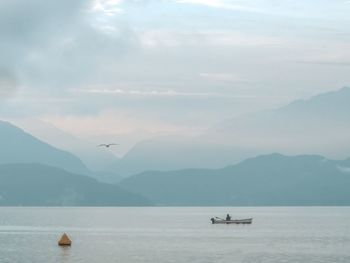 Scenic view of sea and mountains against sky