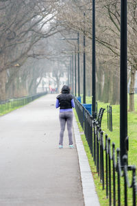 Rear view of woman walking on footpath