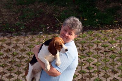 High angle view of woman holding dog on footpath