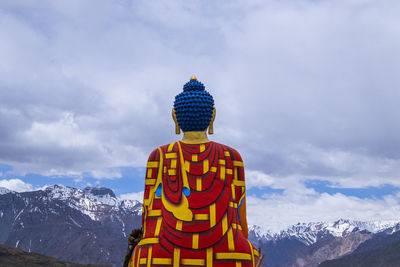 Built structure against snowcapped mountains against sky