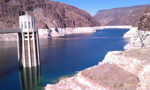 Scenic view of river by mountains against clear sky