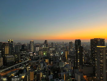 Aerial view of city lit up at sunset