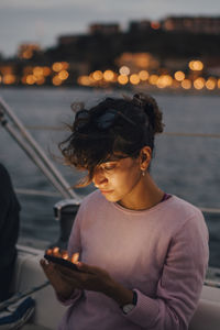 Woman sitting on boat at sea during sunset