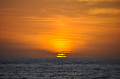 Scenic view of sea against orange sky