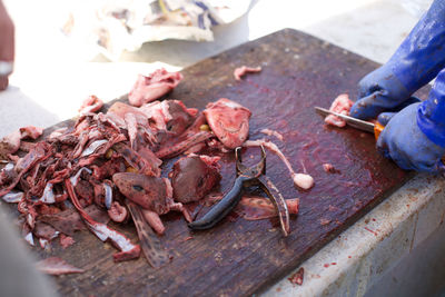 Cropped image of man cutting fishes at market