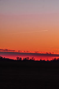 Scenic view of silhouette field against romantic sky at sunset