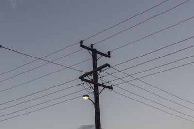 Low angle view of electricity pylon against sky