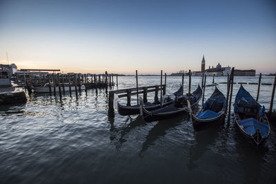 Gondola - traditional boat moored in san marco canal against sky during sunset