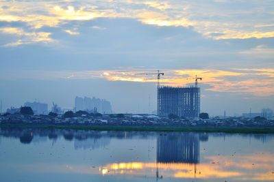 Scenic view of city buildings against sky during sunset