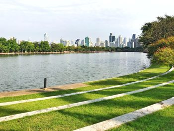 Scenic view of river by buildings against sky