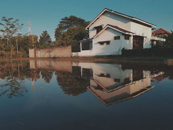 Reflection of building on lake against sky