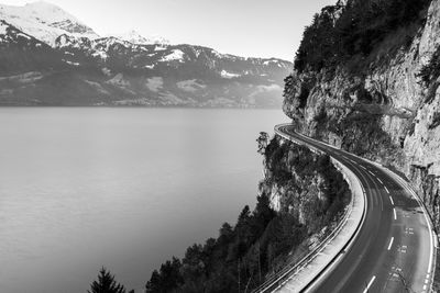Scenic view of road by mountains against sky