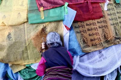 Directly above shot of woman praying on tibetan buddhism prayer flags