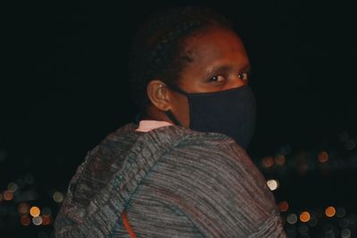 Portrait of young man against black background