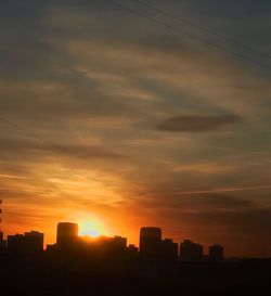 Silhouette buildings against sky during sunset