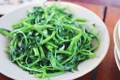 Garlic spinach in plate on table