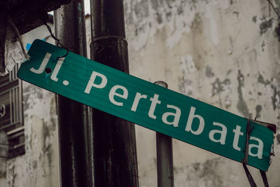 Close-up of information sign against wall