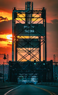 Low angle view of electricity pylon against sky during sunset