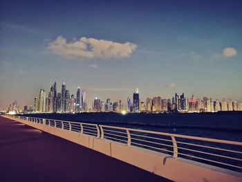 Modern buildings by sea against sky in city