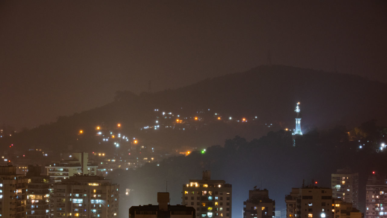 ILLUMINATED CITY BUILDINGS AGAINST SKY AT NIGHT