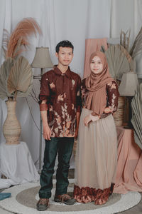 Portrait of young couple standing at home