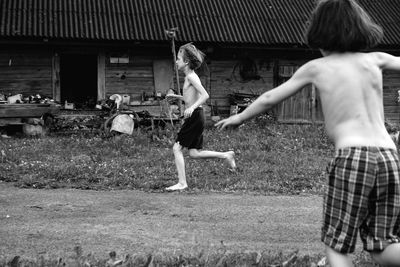 Rear view of boys boys running in the yard