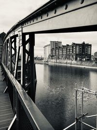 Bridge over river against buildings in city