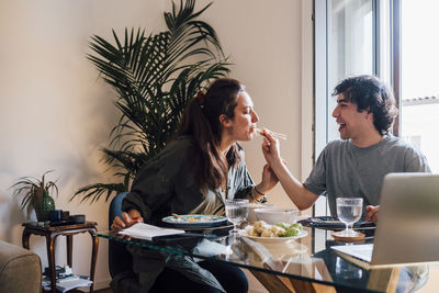 Boyfriend feeding dumpling to girlfriend at home