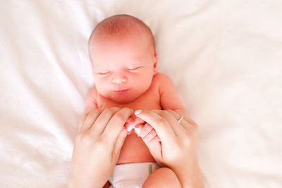 Mother holding hands of sleeping baby