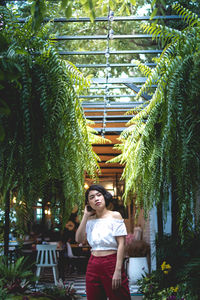 Portrait of woman standing against trees