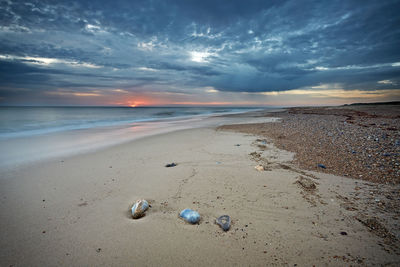 Scenic view of beach against sky during sunset