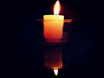 Close-up of illuminated candle against black background