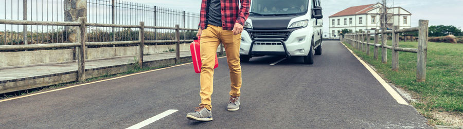 Low section of woman walking on road