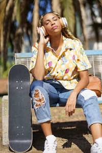 Portrait of young woman sitting in park