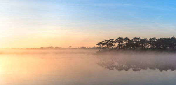 Scenic view of lake against sky at sunset