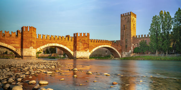 Arch bridge over river against sky