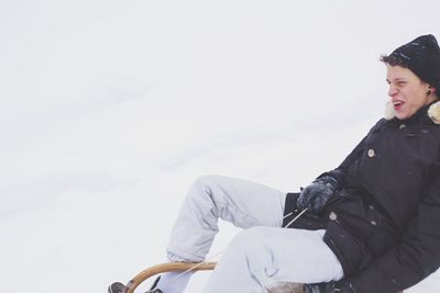Full length of man sitting in snow