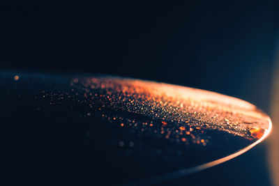 Close-up of water drops on glass against black background