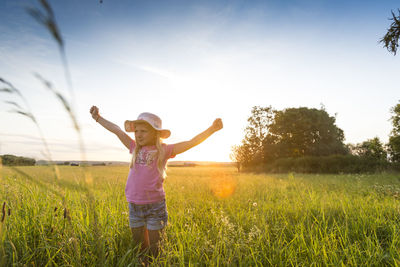 Full length of boy standing on field against sky