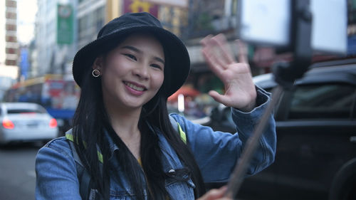 Portrait of smiling young woman in city