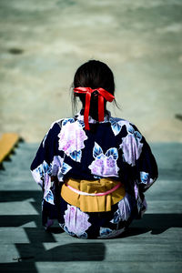 Rear view of woman holding umbrella