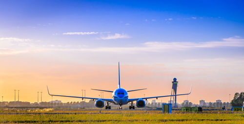 Airplane on airport runway against sky