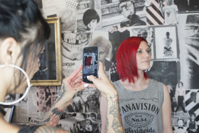 A hair dresser taking a photo of a customer.