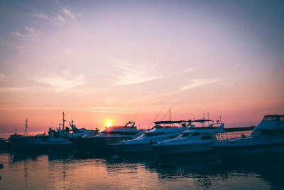 Boats in harbor at sunset