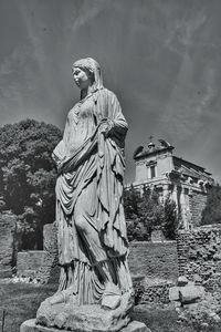 Statue of statues against building against sky