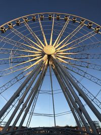 Low angle view of ferris wheel against blue sky