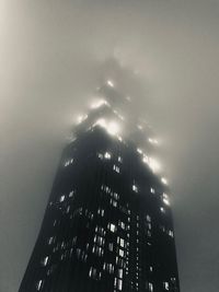 Low angle view of illuminated buildings against sky in city