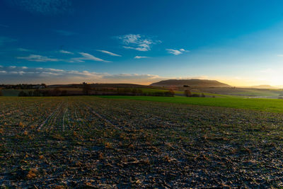 Scenic view of field against sky during sunset