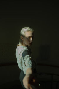 Girl looking at camera while sitting against black background