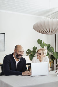 Couple using laptop at home